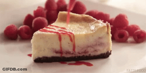 A Slice Of Cheesecake Is On A White Plate With Raspberries . GIF