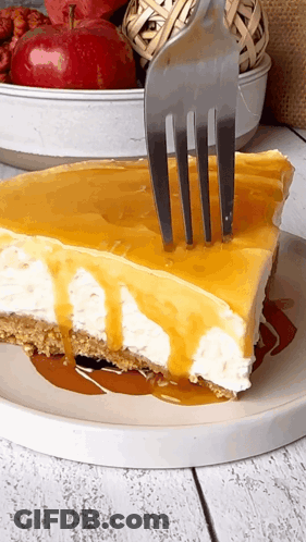 A Slice Of Cheesecake With A Fork Sticking Out Of It GIF
