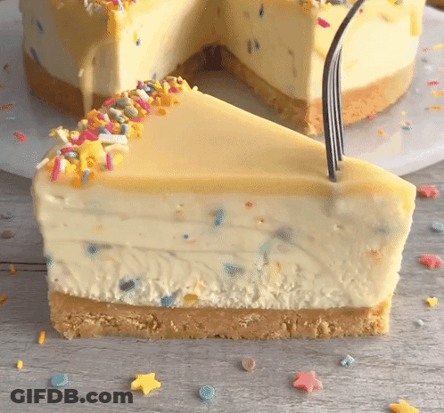 A Slice Of Cheesecake With Sprinkles On Top And A Fork Sticking Out Of It GIF