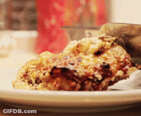 A Slice Of Lasagna Is On A Plate With A Spatula GIF