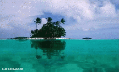 A Small Island With Palm Trees Is Floating In The Middle Of The Ocean GIF
