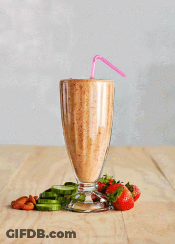 A Smoothie With Strawberries And Cucumbers On The Table GIF
