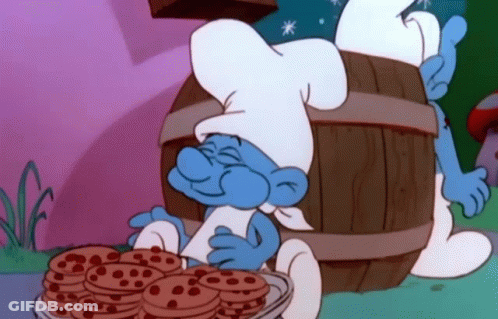 A Smurf In A Chef 'S Hat Is Holding A Bowl Of Chocolate Chip Cookies . GIF