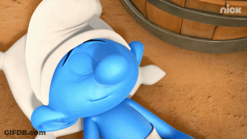 A Smurf Is Laying On The Ground With His Eyes Closed Next To A Barrel That Says Nick On It GIF