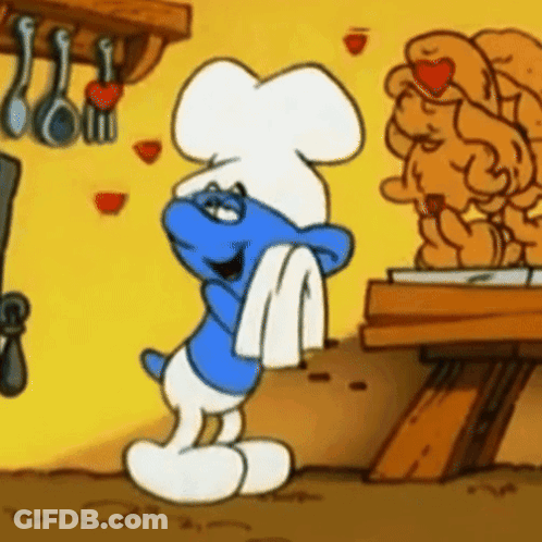 A Smurf Wearing A Chef 'S Hat Is Standing In Front Of A Statue GIF