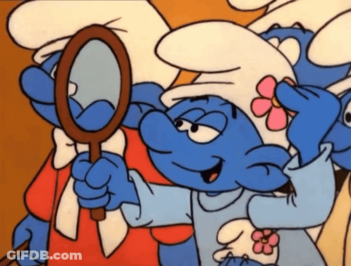 A Smurf With A Pink Flower On His Hat Looks At Himself In A Mirror GIF