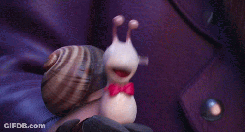 A Snail Wearing A Red Bow Tie Is Being Held By A Person GIF