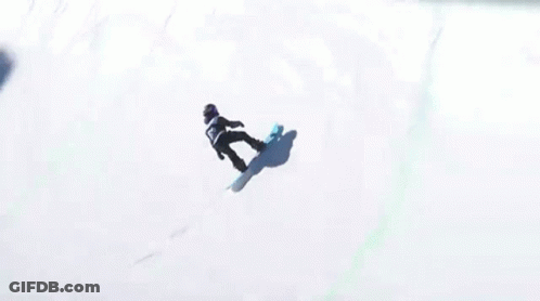 A Snowboarder Is Doing A Trick In Front Of A Fence That Says Stanley On It GIF
