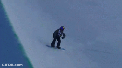 A Snowboarder Is Doing A Trick In The Air While Riding Down A Snowy Hill . GIF
