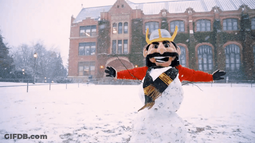 A Snowman Wearing A Viking Costume Is Standing In The Snow GIF