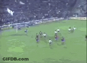 A Soccer Game Is Being Played In Front Of A Banner That Says Itman Gm GIF
