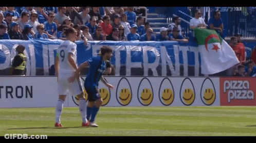 A Soccer Game Is Being Played In Front Of A Banner That Says Pizza Pizza GIF