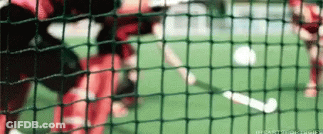 A Soccer Game Is Being Played On A Field Behind A Fence GIF