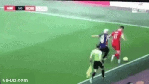 A Soccer Game Is Being Played On A Field With A Referee . GIF