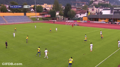 A Soccer Game Is Being Played On A Field With A Scoreboard That Says Dac 0-0 Om GIF