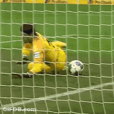 A Soccer Goalie Dives To Catch A Ball With A Postbank Banner In The Background GIF