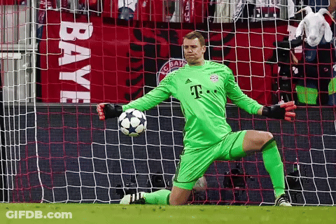 A Soccer Goalie In A Green Jersey With The Letter T On It Is Holding A Soccer Ball In Front Of A Net . GIF