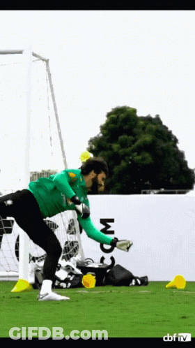 A Soccer Goalie In A Green Jersey With The Word Com On The Wall GIF