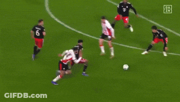 A Soccer Goalie Is Diving To Catch The Ball In Front Of A Heineken Ad GIF