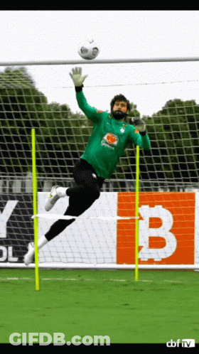 A Soccer Goalie Jumps In The Air To Catch The Ball GIF