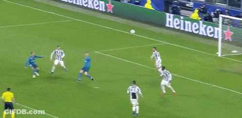 A Soccer Goalie Jumps To Catch A Ball In Front Of A Sign That Says 7 GIF