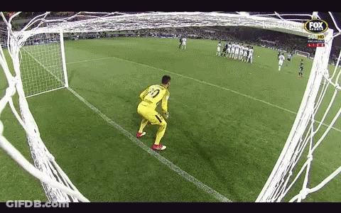 A Soccer Goalie Stands On The Edge Of The Goal Watching A Soccer Game Being Played . GIF