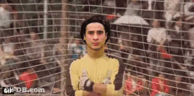 A Soccer Goalie With His Arms Crossed Is Standing In Front Of A Soccer Net . GIF