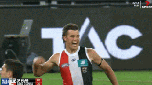 A Soccer Player Celebrates A Goal In Front Of An Ad For Tac GIF