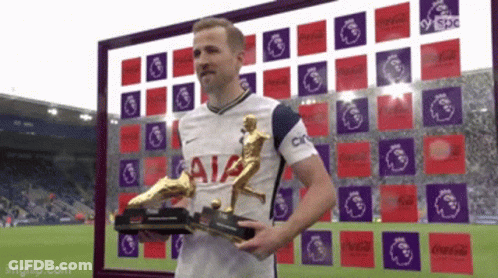 A Soccer Player Holding A Trophy In Front Of A Sign That Says Aia GIF