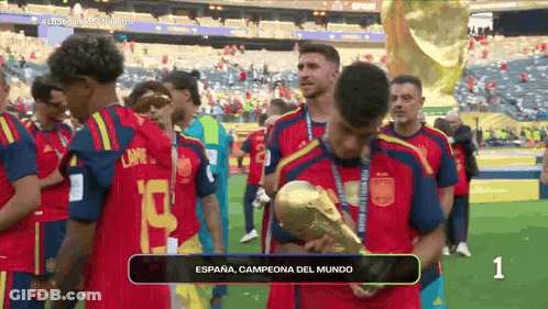 A Soccer Player Holding A Trophy That Says Espana GIF
