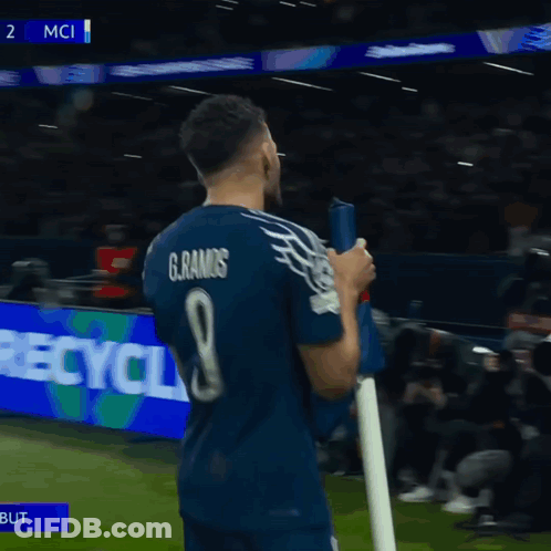 A Soccer Player Holds A Flag In Front Of A Scoreboard That Says 2 Mci On It GIF