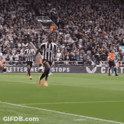 A Soccer Player In A Black And White Striped Jersey Is Running On The Field GIF