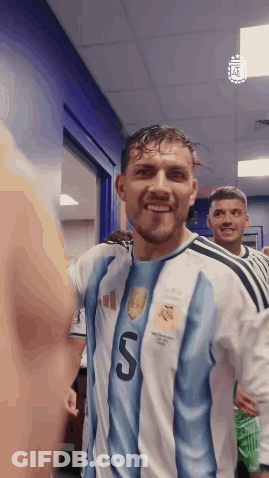 A Soccer Player In A Blue And White Jersey With The Number 5 On It Is Smiling In A Locker Room . GIF