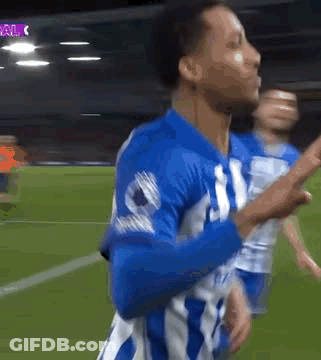 A Soccer Player In A Blue And White Uniform Is Celebrating A Goal On A Field . GIF