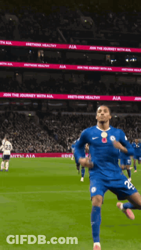 A Soccer Player In A Blue Jersey Is Running On A Field With A Sign That Says Join The Journey With Aia GIF