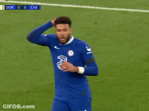 A Soccer Player In A Blue Jersey Is Standing On A Soccer Field With His Hand On His Head . GIF