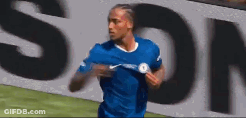 A Soccer Player In A Blue Shirt Is Running On A Field In Front Of A Large Sign . GIF
