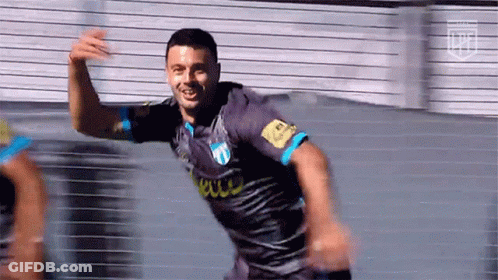 A Soccer Player In A Gray And Blue Jersey Is Celebrating A Goal . GIF