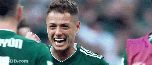 A Soccer Player In A Green Jersey Is Laughing And Celebrating A Goal With His Teammates . GIF