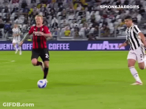 A Soccer Player In A Red And Black Jersey Is Running With The Ball GIF