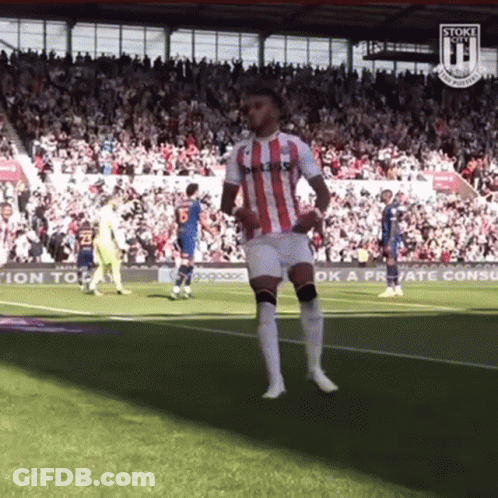 A Soccer Player In A Red And White Striped Shirt Is Dancing On The Field . GIF