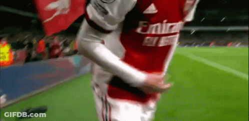 A Soccer Player In A Red Emirates Jersey Is Hugging Another Player On The Field . GIF