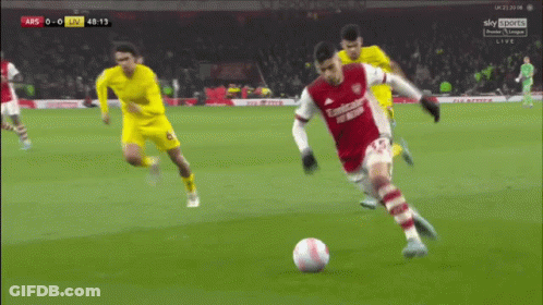 A Soccer Player In A Red Emirates Uniform Kicks A Soccer Ball GIF