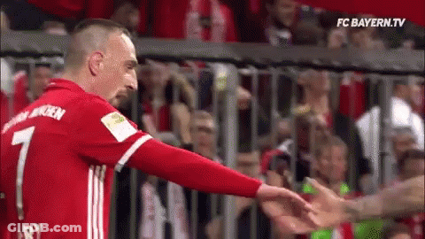 A Soccer Player In A Red Jersey Is Reaching Out To Shake Another Player 'S Hand . GIF
