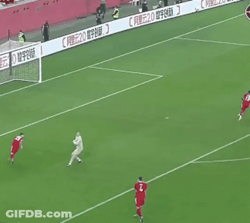 A Soccer Player In A Red Jersey Runs Towards A Ball GIF