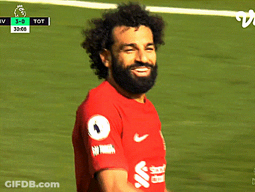 A Soccer Player In A Red Shirt Is Looking Down At Something GIF