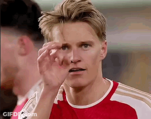 A Soccer Player In A Red Shirt Is Scratching His Nose With His Hand . GIF