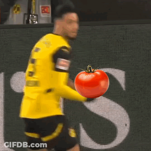 A Soccer Player In A Yellow Jersey Holds A Tomato GIF