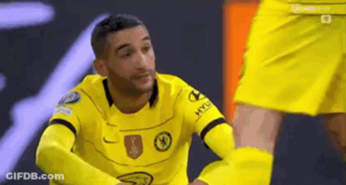 A Soccer Player In A Yellow Jersey Is Kneeling Down Next To Another Soccer Player . GIF