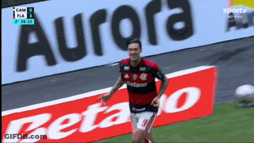 A Soccer Player In Front Of An Ad For Aurora GIF